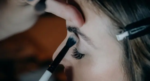 Chuyên gia trang điểm đang lựa chọn bảng màu mắt và phấn má phù hợp với làn da của người mẫu để tạo nên vẻ đẹp hài hòa