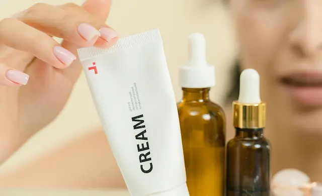 Các loại mỹ phẩm chăm sóc da gồm kem dưỡng và serum tinh chất đặt trên bàn