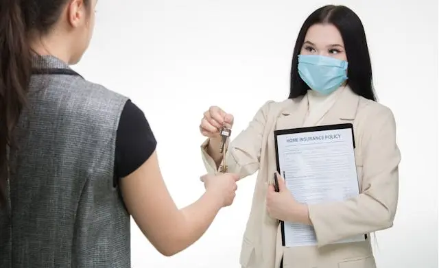 Nhân viên tư vấn trao chìa khóa và hợp đồng bảo hiểm ô tô cho khách hàng