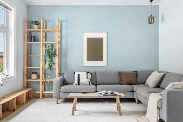 Thiết kế nội thất phòng khách nhỏ tối giản với bộ sofa màu kem và cửa sổ tràn ngập ánh sáng tự nhiên