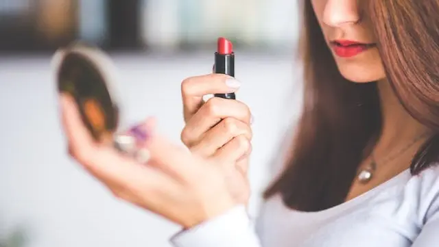 Cận cảnh đôi môi một cô gái đang được tán son màu hồng đào theo phong cách loang màu lòng môi tự nhiên
