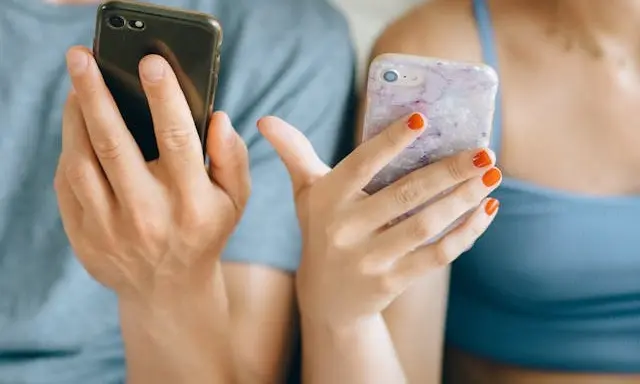 Đôi nam nữ mỉm cười hạnh phúc khi đang gọi điện video nói chuyện với nhau qua màn hình điện thoại thông minh