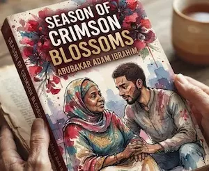 Cuốn tiểu thuyết Season of Crimson Blossoms đặt cạnh tách trà trên mặt bàn